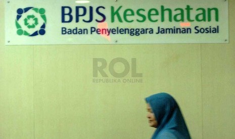 A woman passes under the sign of Bureau of Sosial Security Program in Jakarta. (File photo)