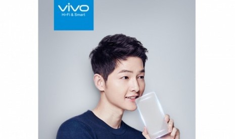 Brand Ambassador Vivo, Song Joong Ki tengah berpose dengan smartphone tembus pandang. 