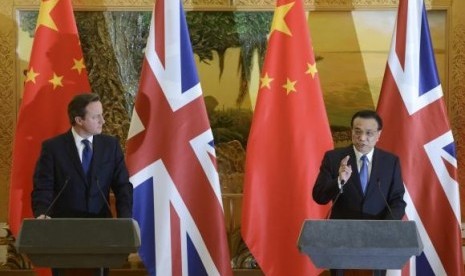 Britain's Prime Minister David Cameron (left) listens to China's Premier Li Keqiang after a signing ceremony at the Great Hall of the People in Beijing December 2, 2013.