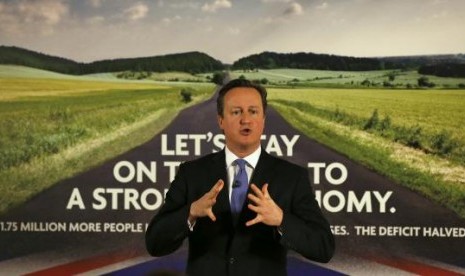 Britain's Prime Minister David Cameron speaks as he stands in front of a new Conservative Party poster, after unveiling it at Dean Clough Mill in Halifax, northern England January 2, 2015.