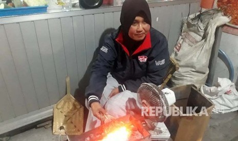 Bu Ari, Penjual Warung Makan Mbah Mo sedang membakar sate landak