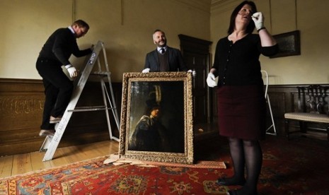 Buckland Abbey staff prepare to hang a recently confirmed self-portrait of Rembrandt, discovered at the Devonshire Abbey in Skipton, England, in this photo dated Wednesday March 13, 2013. 