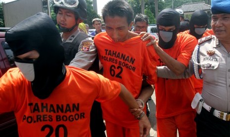 Budiansyah (tengah) pelaku pembunuhan dan pemerkosaan anak dibawah umur, bersama pelaku kriminal lainnya digelandang saat gelar perkara di Mapolres, Cibinong, Kabupaten Bogor, Jawa Barat, Rabu (11/5). 