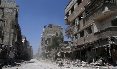 Buildings damaged during battles between Syrian troops and rebels stand along an empty street in Mleiha, some 10 kilometers (6 miles) southeast of downtown Damascus, Syria, Friday, Aug. 15, 2014. 