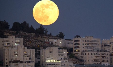 Bulan purnama tampak di langit kota suci Yerusalem.    (AP/Jim Hollander)