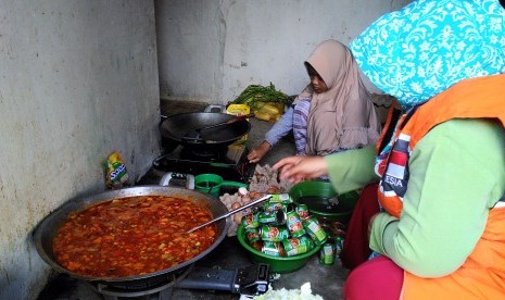 Bunda Syifa (50 tahun) beraktivitas di dapur umum.