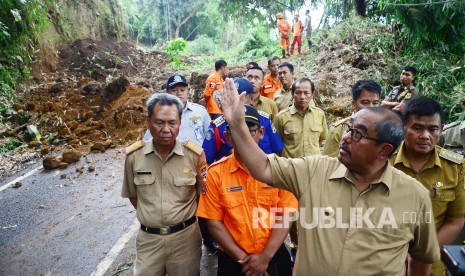 Bupati Bandung Barat Abu Bakar meninjau longsor yang menutupi jalan, di Jalan Kol Masturi, Kecamatan Lembang, Kabupaten Bandung Barat, Senin (12/11). Longsor tersebut memutus jalur Lembang-cimahi.  