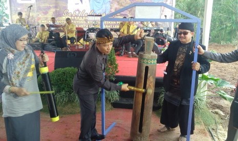 Bupati Bandung H Dadang M Naser memukul pentungan tanda dimulai acara sosialisasi PON XIX 2016 dan Gerakan Sabilulungan di Desa Cibiru Wetan, Kecamatan Cileunyi, Kabupaten Bandung, Senin (30/5).