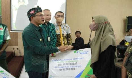 Bupati Bandung HM Dadang Supatiatna (kiri) menyalurkan santunan BJS Ketenagakerjaan kepada para ahli waris yang kepala keluarganya meninggal dunia, Jumat (18/11).   