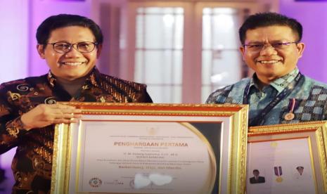 Bupati Bandung HM Dadang Supriatna (kanan) menerima penghargaan dari Menteri Desa Pembangunan Daerah Tertinggal dan Transmigrasi RI H Abdul Halim Iskandar (kiri), atas prestasinya membangun desa di Kabupaten Bandung pada ajang TTG Nusantara ke-XXIII di Cirebon, Selasa (18/10).  