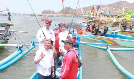 Bupati Banyuwangi, Abdullah Azwar Anas (kedua kanan, memegang kail) saat membuka Fishing Festival di Pantai Grajagan, Banyuwangi, Sabtu (21/9).