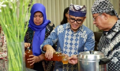 Bupati Banyuwangi Abdullah Azwar Anas menuang jamu untuk Menko Perekonomian Darmin Nasution di Lounge Pelayananan Publik Kantor Bupati Banyuwangi, Kamis (10/8) malam.