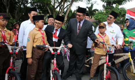 Bupati Banyuwangi Abdullah Azwar Anas menyerahkan sepeda angin untuk siswa kurang mampu.