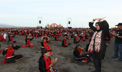 Bupati Banyuwangi Ipuk Fiestiandani menyapa penari gandrung yang berlatih menari kolosal di Pantai Boom Marina, Banyuwangi, Jawa Timur, Jumat (28/10/2022). 