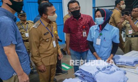 Bupati Batang Wihaji (ketiga kiri) berbincang dengan karyawan pabrik di industri garmen PT. Batang Apparel Indonesia, Kabupaten Batang, Jawa Tengah, Senin (19/4/2021). Pemerintah setempat mewajibkan semua perusahaan yang ada di Kabupaten Batang untuk membayarkan tunjangan hari raya (THR) sesuai undang-undang yang berlaku dan menghimbau bagi perusahaan yang mengalami pailit agar mengkomunikasikan dengan pemerintah daerah dengan tujuan menemukan solusi bersama. 