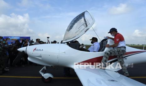 Bupati Jember Hendy Siswanto (kedua kanan) menaiki pesawat bermotor tipe Aquilla di Bandara Notohadinegoro, Jember, Jawa Timur, Ahad (30/5/2021). Bupati masih mematangkan rencana joyflight keliling Jember dengan pesawat Cessna dari bandara Notohadinegoro tiap akhir pekan.