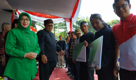 Bupati kabupaten sukabumi marwan hamami menyerahkan kartu tanda peserta bpjs kepada para nelayan di palabuhanratu. 