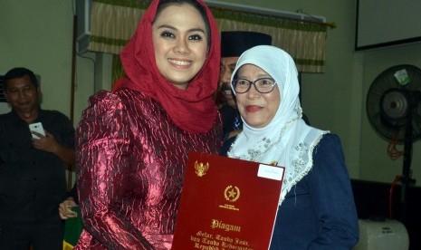 Bupati Karawang, dr.Cellica Nurrachadiana saat menyerahkan penghargaan tanda kehormatan Satya Lancana Karya Satya Presiden Republik Indonesia di Karawang beberapa waktu lalu.