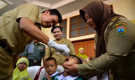 Bupati Kudus Mustofa (kiri) meneteskan vaksin polio kepada anak saat peresmian Pekan Imunisasi Nasional (PIN) Polio 2016 di Desa Gondang Manis, Kudus, Jawa Tengah (14/3).