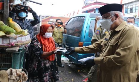 Bupati Malang, M Sanusi membagikan masker kepada masyarakat Lawang, Kabupaten Malang, Selasa (3/8). Sanusi menegaskan, setiap orang yang akan berkunjung dan berada di Kabupaten Malang wajib memakai masker. oleh karena itu, di pintu masuk tol menuju Kabupaten Malang dilakukan penyekatan.