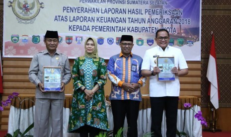 Bupati Musi Banyuasin (Muba) Dodi Reza  Alex (kanan) dan Ketua DPRD Muba Abusari (kiri) menerima laporan hasil pemeriksaan (LHP) atas laporan keuangan Pemerintah Kabupaten Muba tahun anggaran 2018 dari anggota V Badan Pemeriksa Keuangan (BPK) Isma Yatun, Selasa (19/3) digedung BPK RI Perwakilan Sumsel. 