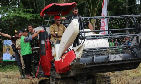 Bupati Pidie, Roni Ahmad, saat mengikuti Gerakan Panen dan Percepatan Tanam Padi yang dilaksanakan di Gampong Tangkueng, Kecamatan Sakti, Pidie, Aceh.