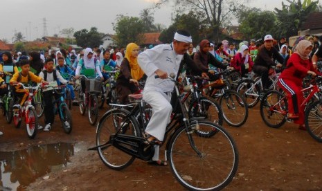 Bupati Purwakarta Dedi Mulyadi bersepeda bersama ratusan siswa siswi baru SMP Negeri 1 Purwakarta, Kamis (23/7). Dedi mengajak seluruh siswa siswi di Purwakarta menggunakan transportasi sepeda ke sekolah. Foto: Rachmat Santosa Basarah 