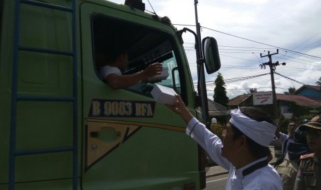 Bupati Purwakarta, Dedi Mulyadi membagikan makanan kepada para pengendara yang terjebak macet di Tol Cipularang menyusul adanya perbaikan Jembatan Cisomang, Kamis (29/12).