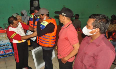 Bupati Semarang, H Ngesti Nugraha  mengenakan rompi pelampung kepada perwakilan nelayan Rawapening, pada acara penyerahan bantun asuransi nelayan dan perlengkapan pendukung keselamatan di Balai Desa Asinan, Kecamatan Bawen, Kabupaten Semarang, Selasa (22/11).