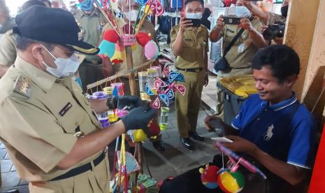 Bupati Semarang, Peni Ngesti Nugraha (kiri) menegur dan memberikan edukasi kepada salah seorang pedagang mainan anak- anak yang kedapatan abai mengenakan masker saat beraktivitas di Pasar bandarjo, Ungaran, Kabupaten Semarang, Senin (3/5). Bupati mita kepada seluruh Lurah Pasar yang ada di daerahnya untuk mengoptimalkan pengawasan protocol kesehatan di pasar tradisional menjelang lonjakan aktivitas pasar jelang hari raya Idul Fitri tahun ini.