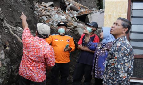 Bupati Sleman, Kustini Purnomo, saat meninjau rumah yang mengalami kerusakan akibat terkena longsor.