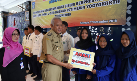 Bupati Sleman, Sri Purnomo, memberikan beasiswa dan bantuan kepada  siswa-siswa berprestasi di Kabupaten Sleman.