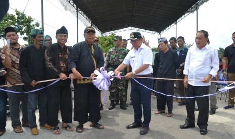 Bupati Sumedang H Eka Setiawan tengah menggunting pita tanda peresmian pembangunan tiga proyek infrastruktur yang dibiayai pemerintah dan swadaya masyarakat di Desa Palabuan, Kecamatan Ujungjaya, Kabupaten Sumedang, Ahad (14/1).