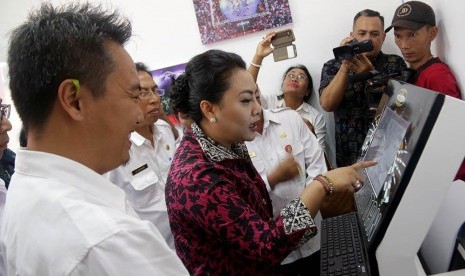 Bupati Tabanan Bali, Ni Putu Eka Wiryastuti saat menunjukan hasil pembuatan SKCK melalui anjungan mesin Taman Serasi di Kantor Kecamatan Kerambitan, Rabu (7/2).