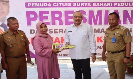 Bupati Tangerang Ahmed Zaki Iskandar menyerahkan simbol kunci kepada salah satu warga saat meresmikan bedah rumah marbot masjid dari program Jaringan Nurani Rakyat (Janur) di Kampung Cituis, Desa Surya Bahari, Kecamatan Pakuhaji, Kabupaten Tangerang, Selasa (5/9/2023).