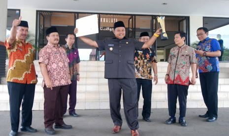 Bupati Tasikmalaya H Uu Ruzhanul Ulum menunjukkan piala dan piagam juara I lomba website antarpemerintah kabupaten dan kota se-Jawa Barat dalam kegiatan Kominfo Award 2017 yang diselenggarakan Dinas Komunikasi dan Informatika Jabar di Trans Luxury Hotel, Kota Bandung, Rabu (13/9). 