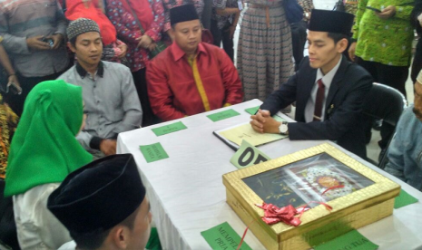 Bupati Tasikmalaya Uu Ruzhanul Ulum (kemeja merah) menjadi saksi dalam gelaran nikah massal di gedung Islamic Center, Kabupaten Tasikmalaya, Jawa Barat, Jumat (9/2). 