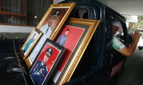 Bupati terpilih Uu Ruzhanul Ulum (kanan), mengangkut pakaian dan foto dirinya yang disimpan di Pendopo Lama Kabupaten Tasikmalaya, Jawa Barat, Senin (7/3). 