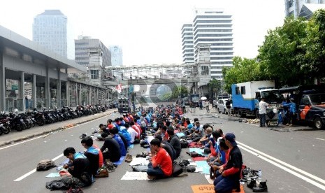 Buruh dari berbagai aliansi melakukanshalat Jumat saat 