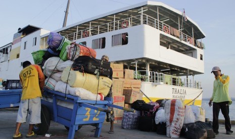 Buruh mengikat barang milik calon TKI tujuan Negeri Sabah, Malaysia yang telah disusun di gerobak di Pelabuhan Tunon Taka Kabupaten Nunukan, Kalimantan Utara, Senin (7/3).