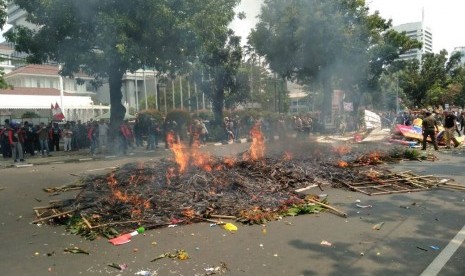 Buruh yang tergabung dalam LSP LEM SPSI membakar puluhan karangan bunga di depan Balai Kota DKI Jakarta, Jakarta Pusat, Senin (1/5). 