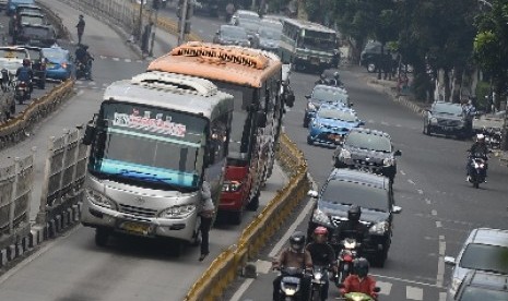 Bus Kopaja masuk jalur busway dengan menaikan penumpang sembarangan di Kawasan Duren Tiga, Jakarta Selatan, Selasa (7/4).