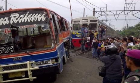  Bus Metromini ditarik mobil derek dari rel kereta api di pintu perlintasan kereta api Pasar Minggu, Jakarta Selatan, Senin (17/6).