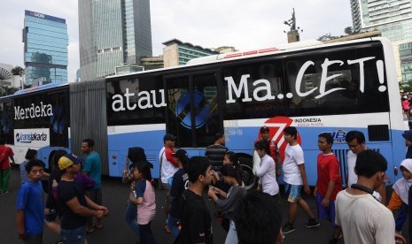 Bus Transjakarta bertuliskan Merdeka Atau Macet melintasi Kawasan Bundaran HI di Jakarta, Minggu (28/8). 