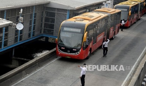  Bus Transjakarta menaikan dan menurunkan penumpang di Halte Harmoni, Jakarta, Senin(1/5).