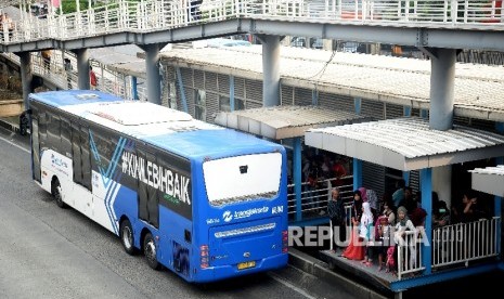 Bus Transjakarta menaikan dan menurunkan penumpang di Halte Harmoni, Jakarta, Senin(1/5).