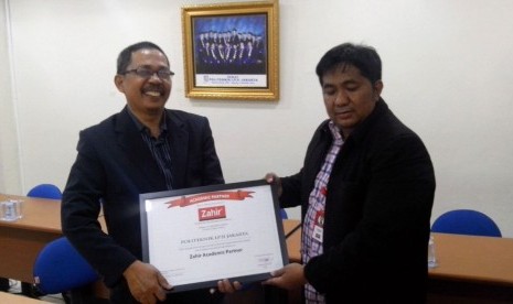 Business Manager PT Zahir Internasional Indra Septiady (kanan) dan Ketua Program Komputerisasi Akuntansi Politeknik LP3I Hamizar menunjukkan piagama kerja sama PT Zahir Internasional dan LP3I.