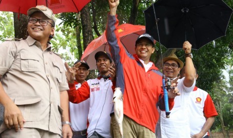 Calon gubernur DKI Jakarta nomor urut 3, Anies Baswedan, mengikuti aksi macing bersama relawan Anies-Sandi di pemancingan umum Kabeda, Kukusan Beji, Depok, Sabtu (14/1).