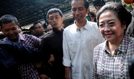 Cagub DKI Jakarta Joko Widodo (Tegah) usai mendampingi Ketua Umum PDI Perjuangan Megawati Soekarno Putri (depan) mengikuti Pilkada DKI Jakarta di tempat pemungutan suara (TPS) 031 Kebagusan, Jakarta Selatan, Rabu (11/4). Jutaan warga ibukota memberikan sua