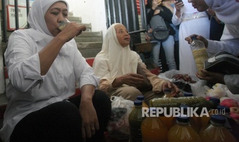 Cagub Jatim nomor urut satu Khofifah Indar Parawansa (kiri) mencoba minuman jamu tradisional saat melakukan kampanye 'blusukan' di Pasar Tradisional Wlingi, Blitar, Jawa Timur, Rabu (21/2).